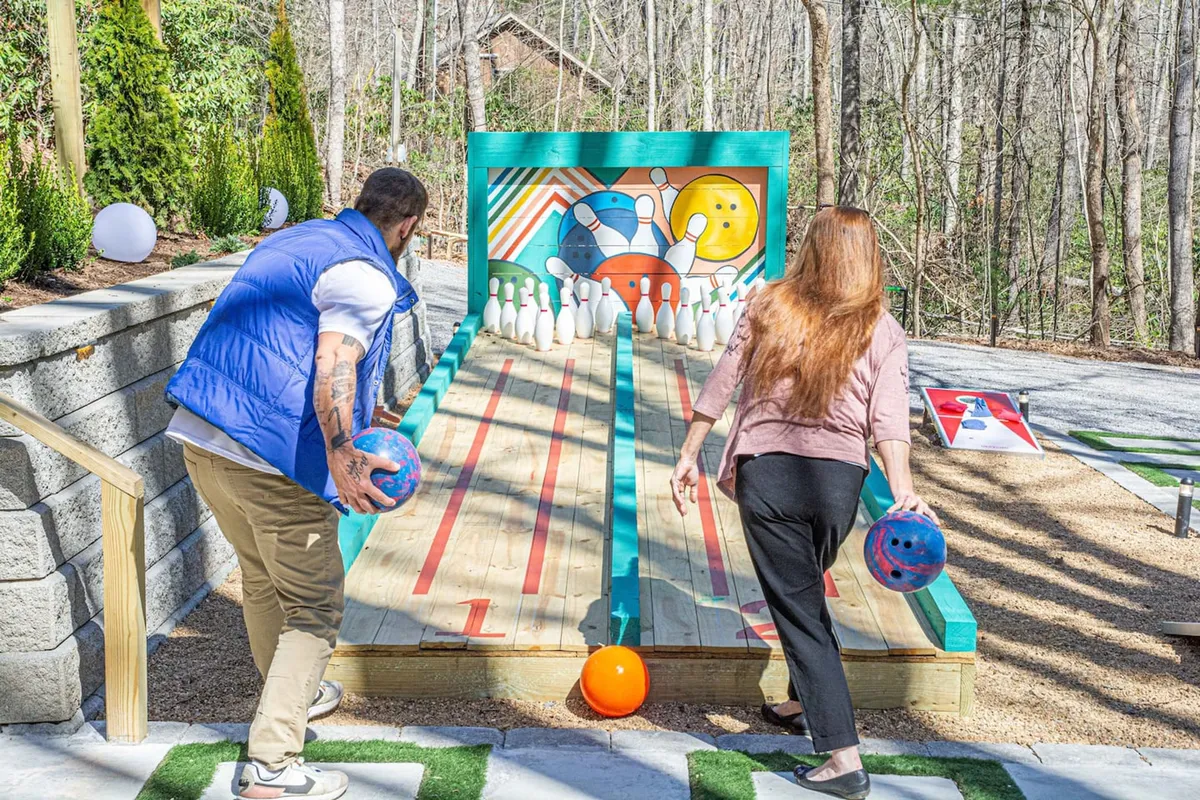 Friends enjoy a lively game at an outdoor bowling alley, complete with colorful pins and a cheerful, laid-back atmosphere. The environment is designed for fun, socializing, and building memories together.